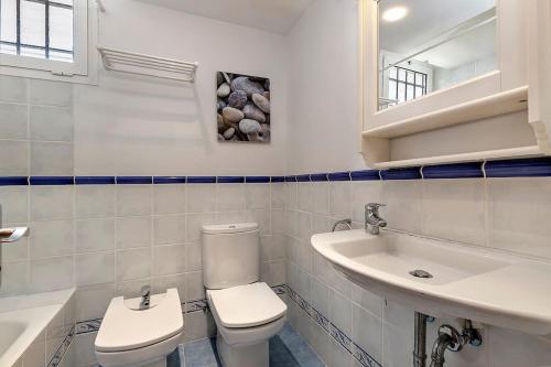a bathroom with a toilet and a sink at Llenaire 2, Sea view, pool, AC in Port de Pollensa