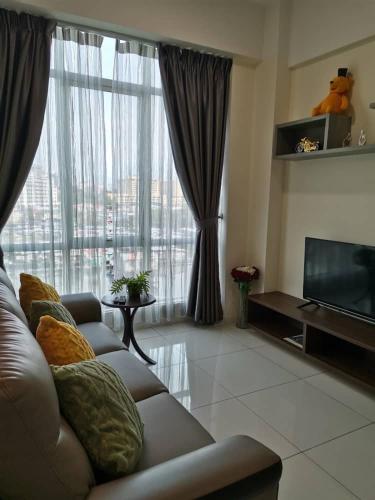 a living room with a couch and a large window at Sutera Avenue - Jom Summer Suite in Kota Kinabalu
