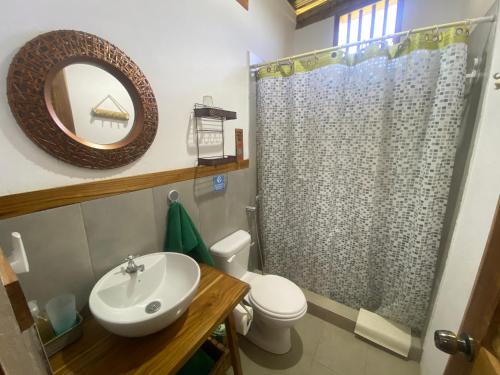 een badkamer met een wastafel, een toilet en een spiegel bij Bungalows Ayampe in Ayampe
