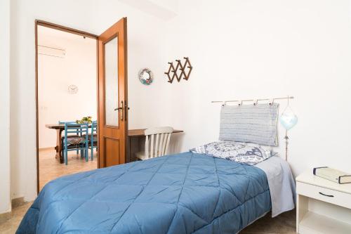 Un dormitorio con una cama azul y una mesa en Casa Masala Irgoli, en Irgoli