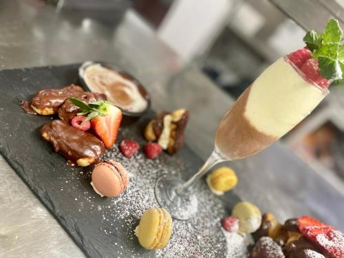 a plate of food with a spoon and a drink at The Boars Head Hotel in Sudbury