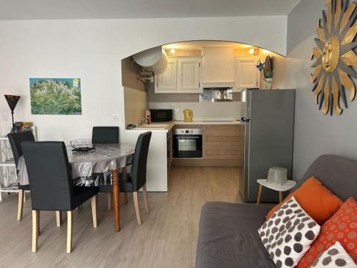 cocina y sala de estar con mesa de comedor y sofá en Appartement La Pyrène en Argelès-Gazost