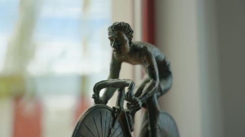 a statue of a man standing next to a bike at Gastenverblijf 't Hof van Eden in Wingene
