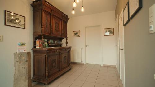 a hallway with a large wooden cabinet in a room at Gastenverblijf 't Hof van Eden in Wingene