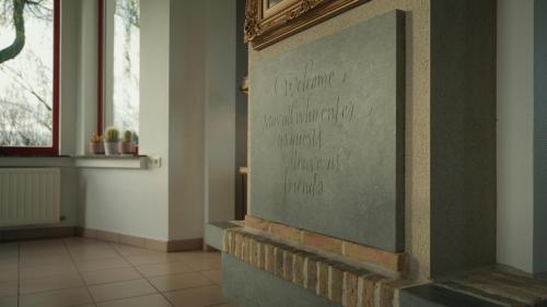a sign on a wall in a room at Gastenverblijf 't Hof van Eden in Wingene