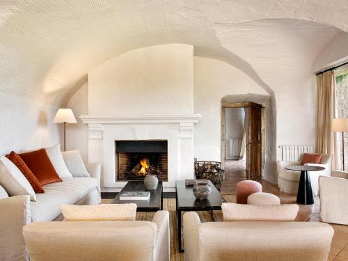 a living room with a couch and a fireplace at Mas de Torrent Hotel & Spa, Relais & Châteaux in Torrent