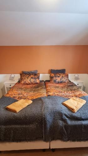 a bedroom with two beds with blankets and pillows at Fornilækur Guesthouse in Blönduós