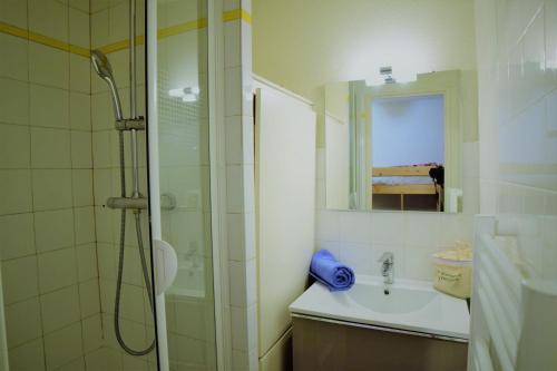 une salle de bain blanche avec une douche et un lavabo dans l'établissement Andromede - 35 - Studio coeur station - 4 pers, à Les Deux Alpes