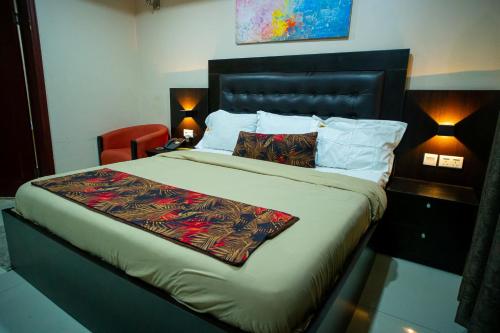 ラゴスにあるKABACHI STACKのベッドルーム1室(大型ベッド1台、テーブル、ランプ2つ付)