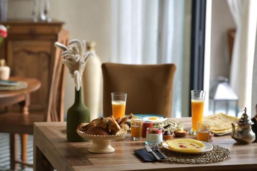 een tafel met een bord eten en een glas sinaasappelsap bij Riad Palau Marrakech in Marrakesh