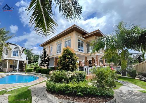 Palawan Twin-Bed Paradise with a Balcony plus FREE Pool, Gym & Parking-7Kunzite في مدينة بورتوبرنسس: منزل فيه مسبح و نخلة
