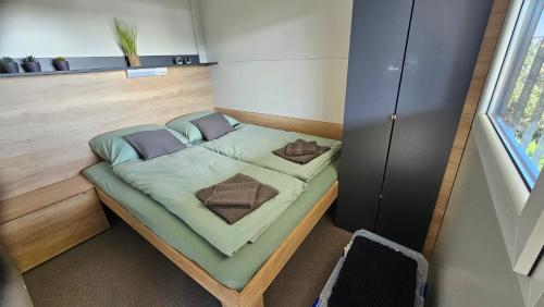 un piccolo letto in una piccola stanza con finestra di CHARTA mobile home Nada a Pirovac (Slosella)