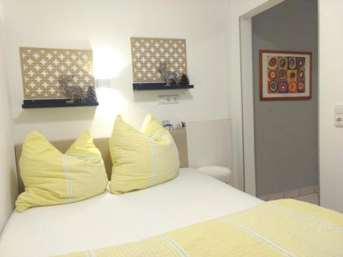 a bedroom with a bed with yellow pillows at Ferienwohnungen Haus Paradies in Sankt Englmar