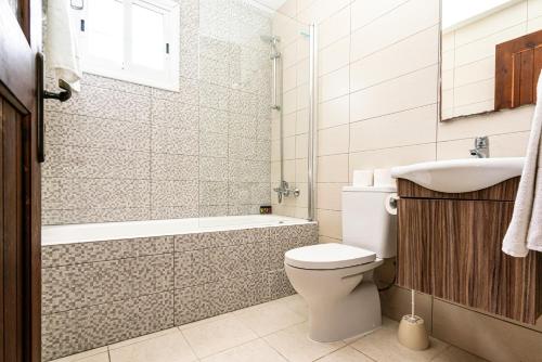a bathroom with a toilet and a tub and a sink at Kotsias Corallia Villas in Coral Bay