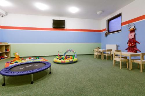 a classroom with a play room with a table and chairs at Pension Hollmann in Harrachov