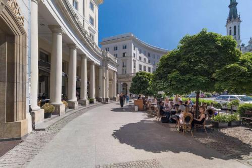 a group of people sitting at tables on a city street at Apartament K3 in Warsaw