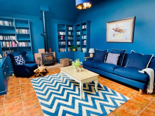 a blue living room with a blue couch and a table at The Lodge in Kelso