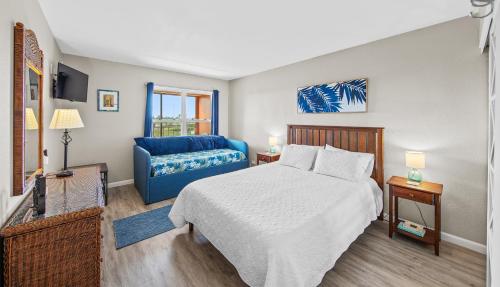 - une chambre avec un lit et un canapé bleu dans l'établissement Gulf View 1 Unit 403, à South Padre Island
