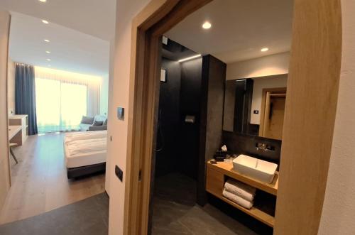 a bathroom with a sink and a bed in a room at Vetta Alpine Relax in Livigno