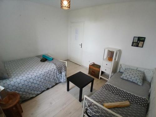 ein Schlafzimmer mit 2 Betten und einem TV. in der Unterkunft Manoir de kerozet - Chambres chez l'habitant in Plouider