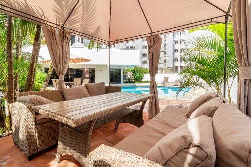 a patio with a table and chairs and a pool at H4 Fortune Jardins in Sao Paulo