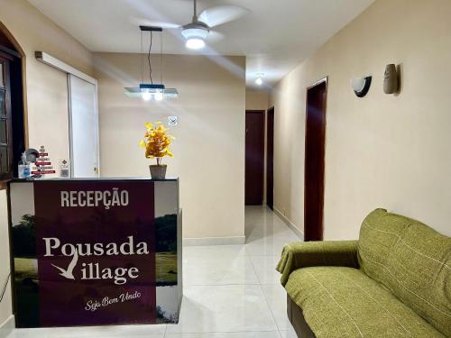 un soggiorno con divano e un cartello di Pousada Village Rio Centro a Rio de Janeiro