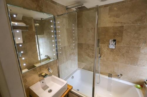 y baño con ducha, bañera y lavamanos. en The Cheviot Hotel, en Bellingham