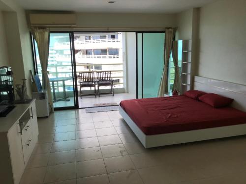 um quarto com uma cama vermelha e uma varanda em Sea 14 Big Balcony em Pattaya Sul