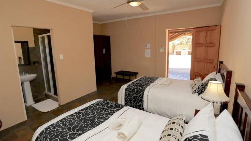 Habitación de hotel con 2 camas y baño en Stoney's Country Hotel, en Gochas