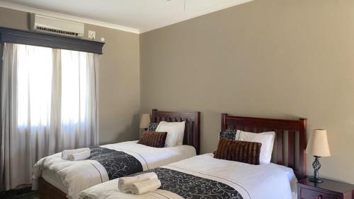 1 dormitorio con 2 camas y ventana en Stoney's Country Hotel, en Gochas