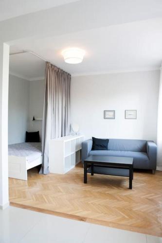 a living room with a blue couch and a bed at Elegancki apartament / wi fi / centrum in Warsaw