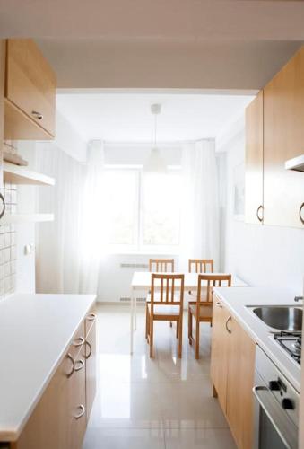 a kitchen with a table and two chairs and a table and a kitchen with at Elegancki apartament / wi fi / centrum in Warsaw