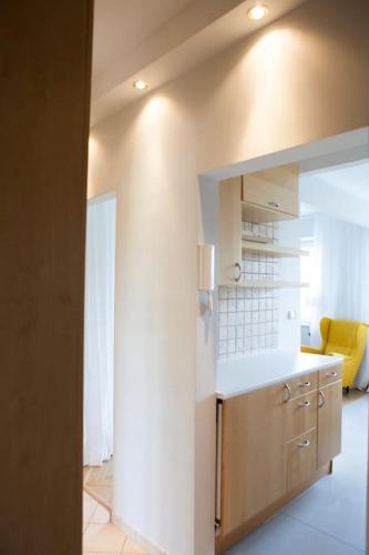 a kitchen with a counter and a yellow chair at Elegancki apartament / wi fi / centrum in Warsaw