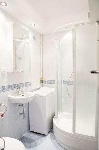 a white bathroom with a shower and a sink at Elegancki apartament / wi fi / centrum in Warsaw