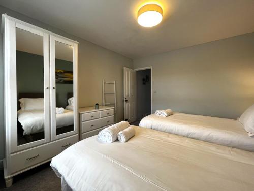 a bedroom with two beds and a large mirror at York Street in Cowes