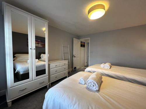 a bedroom with two beds and a mirror at York Street in Cowes
