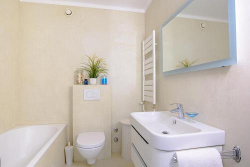 a bathroom with a sink and a toilet and a mirror at Tourelle 2 - Spacieux appartement dans le centre de Genève in Geneva