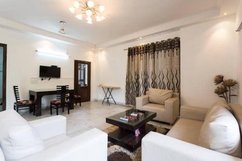 a living room with white furniture and a piano at 1BHK Service Apartment in Nainital