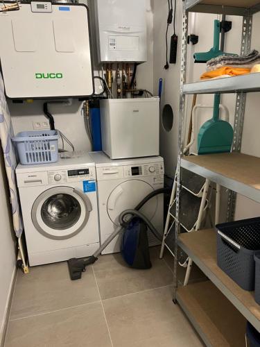 a laundry room with a washer and a washing machine at Logies La Parmentière in De Panne