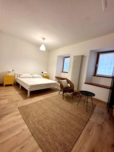 - une chambre avec un lit, une chaise et un tapis dans l'établissement Appartamento la Torretta, con giardino!, à Crevoladossola