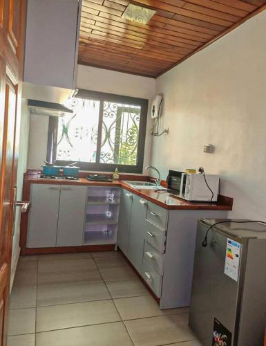a small kitchen with a sink and a window at ORION RESIDENCY BONABERIE in Douala