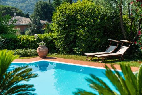 una piscina con due sedie a sdraio e un vaso di Villa Telli a Garda
