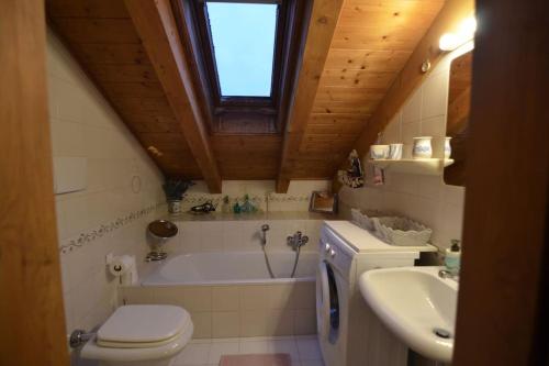 uma casa de banho com uma banheira, um WC e um lavatório. em Cozy attic in the center of San Vito em San Vito di Cadore