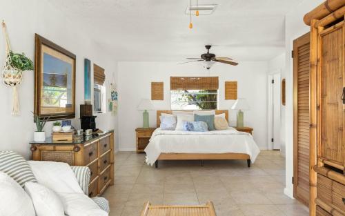 een slaapkamer met een bed en een bank bij Coconut Cove Peaceful Retreat Wpool And Canal in Cocoa Beach
