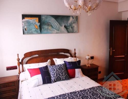 a bedroom with a bed with red and blue pillows at Tranquilo apartamento en Pola de Siero in Siero