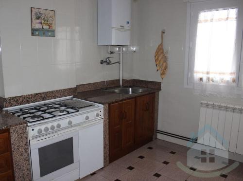 a kitchen with a white stove and a sink at Tranquilo apartamento en Pola de Siero in Siero