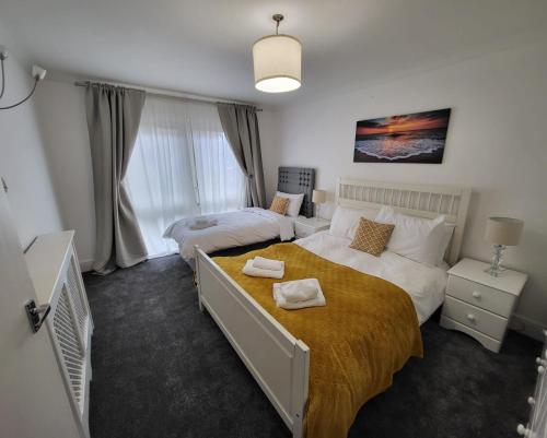 a bedroom with two beds and a tv in it at Deluxe 2Bed Duplex Apartment & parking in London