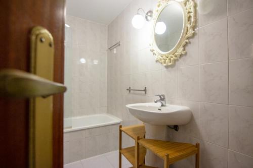 een badkamer met een wastafel, een spiegel en een bad bij RentalSevilla A los pies de la Alameda de Hércules in Sevilla