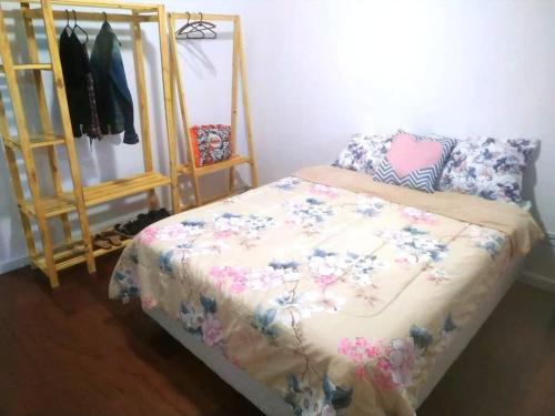 サン・ジョゼー・ドス・ピニャイスにあるCasa da tia Ju!のベッドルーム1室(花柄の掛け布団付きのベッド1台付)
