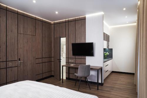 a bedroom with a bed and a desk with a television at BonApart Maidan by UHM in Kyiv